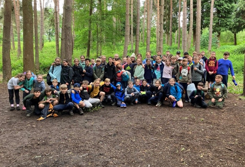 Year 6 pupils pose in a group on the forest floor at Penshurt Place in Kent